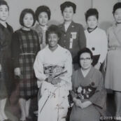 1964東京オリンピック女子選手村の着付け会で着物を着たアメリカ合衆国(United States)陸上 エリーノモントゴックメリー選手(Eleanor Montgomery)と女子選手村村長佐閑晴様(後左から4人目)、上田美枝、上田嘉一朗商店スタッフ