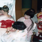 平成美枝きもの資料館ハンガリー展で子どもたちに着物を着せてあげるスタッフ